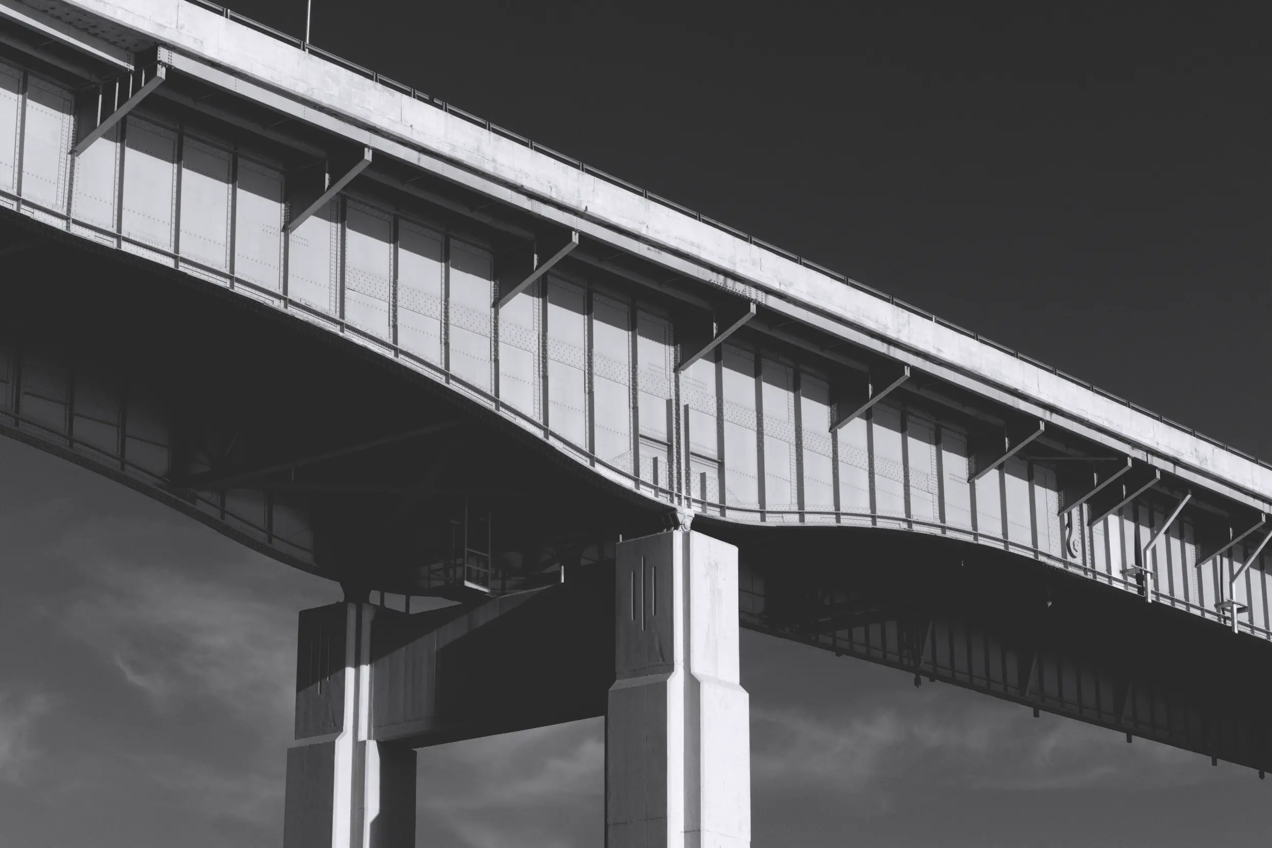 Black and white photo of the underside of a bridge in Buffalo, NY that shows a interesting three line design.